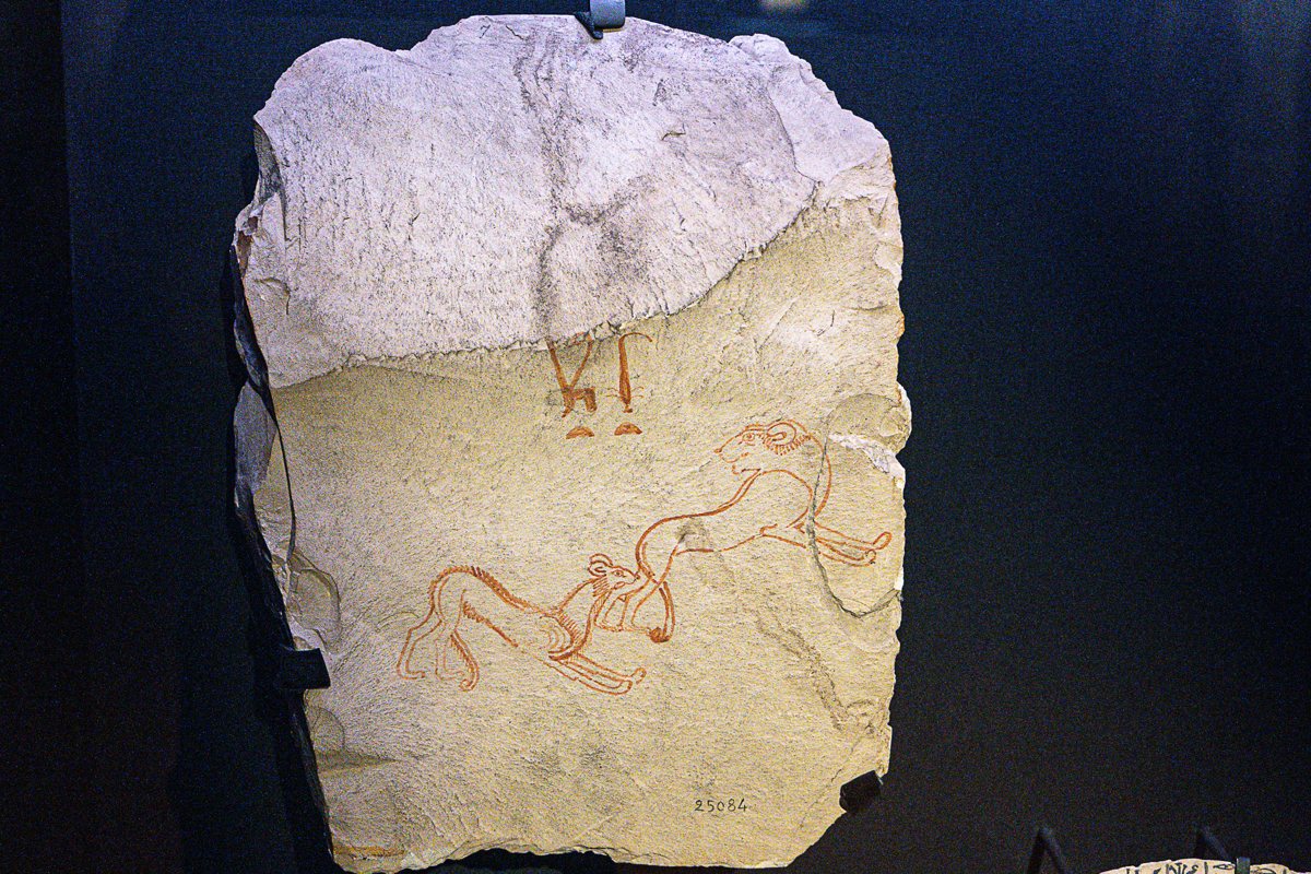 A limestone ostracon drawn in red ink: the scribe Hay adoring the goddess Anuket, shown as a gazelle.